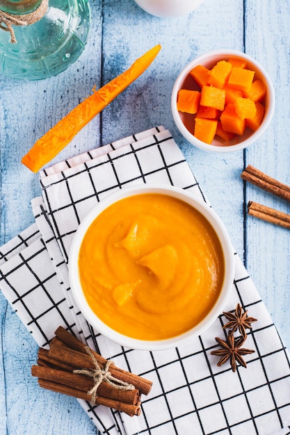 Photo purée de citrouille biologique dans un bol de citrouille et d'épices pour la cuisson en haut et en vue verticale