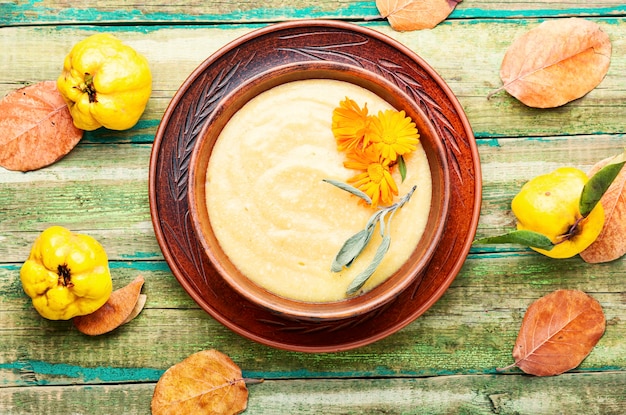 Photo purée de coing ou soupe à la crème.soupe de fruits sur table en bois