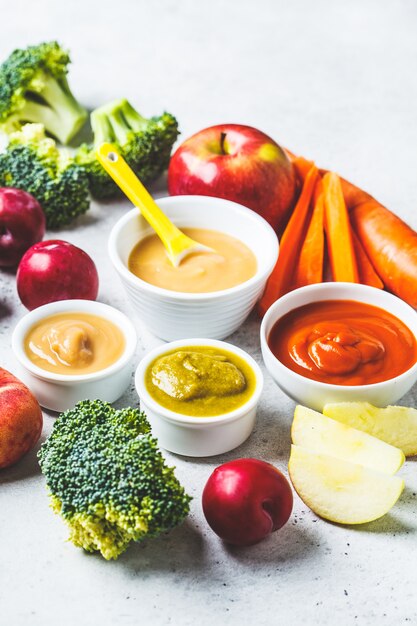 Purée de fruits et légumes dans des bols blancs avec ingrédients.