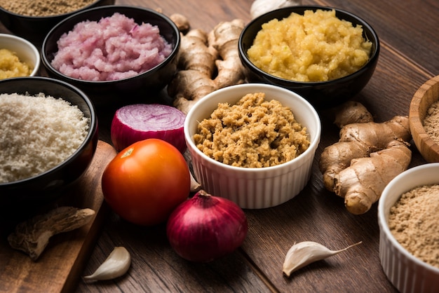 Purée de gingembre frais, ail, oignon et tomate également connue sous le nom de pâte Adrak, Lahsun, Pyaj et Tamatar en hindi. Ingrédients de base de la nourriture indienne dans un bol sur fond de mauvaise humeur