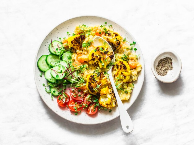 Purée de lentilles jaunes à la citrouille, chou-fleur et légumes au curcuma cuits au four dans un bol