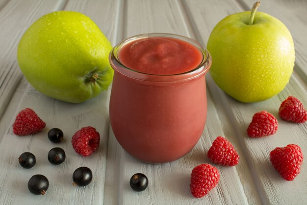 Purée de pommes, framboises et cassis sur le bois gris