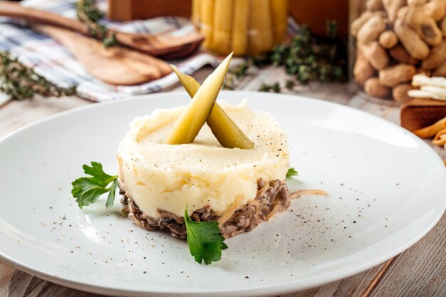 Purée de pommes de terre au bœuf en sauce crémeuse et cornichons