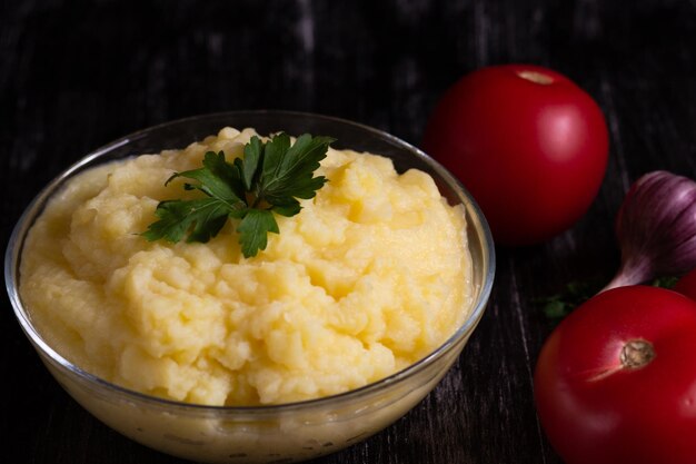 Purée de pommes de terre dans un bol en verre sur fond noir