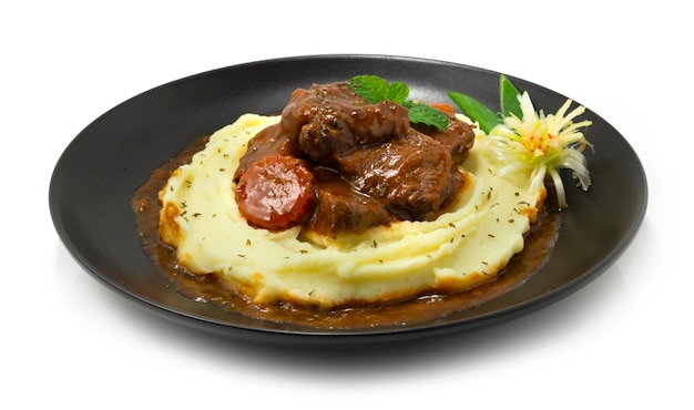 Purée de pommes de terre avec ragoût de bœuf à la sauce au vin rouge Délicieux plat principal Cuisine européenne Décoration de style légumes sculptés sideview