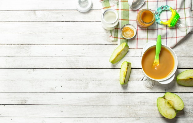 Purée de pommes vertes et de lait frais pour bébé dans un biberon.