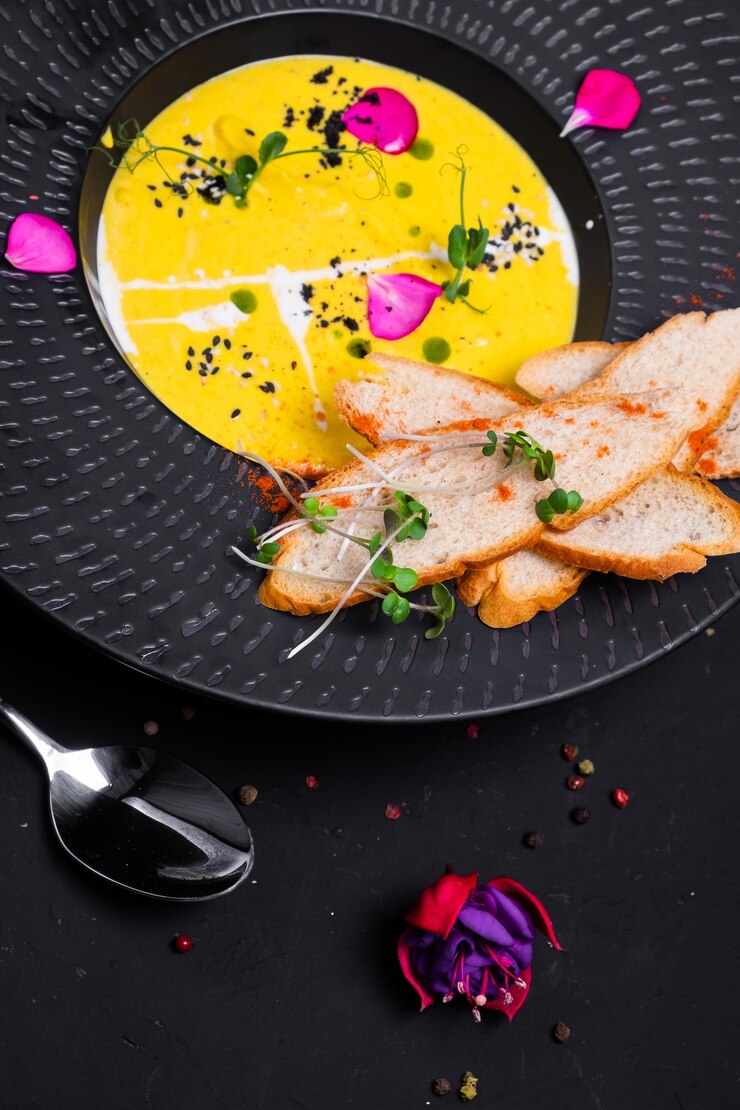 Photo purée de potiron à la crème, croûtons de blé et légumes verts sur une surface sombre. vue rapprochée