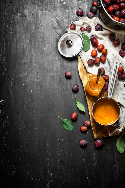 Purée de prunes mûres dans une petite casserole sur un tableau noir.