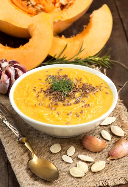 Purée de soupe de potiron frais et crudités sur une table en bois