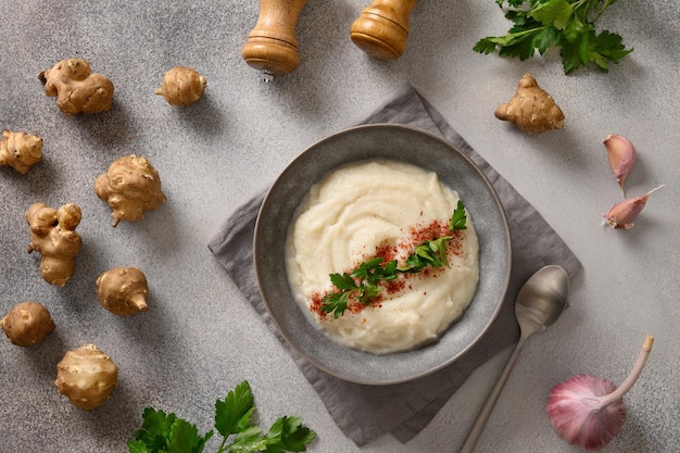 Purée de topinambour décorée de persil frais dans un bol