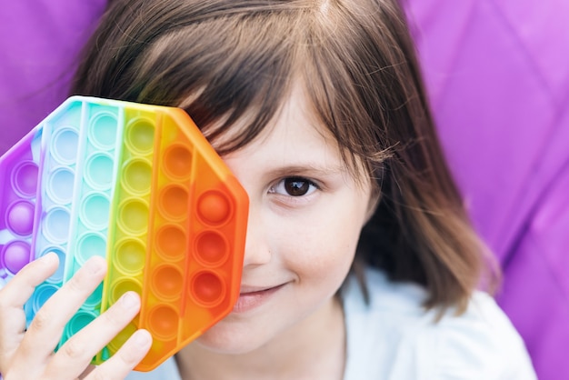 Photo push pop it et fossette simple dans les mains des enfants close up of portrait little girl with a modern popit toy