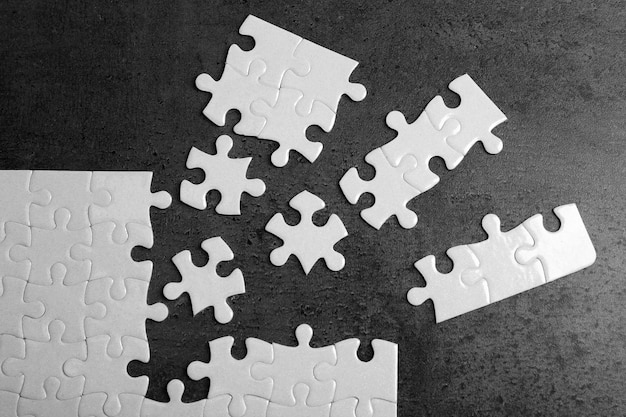 Puzzle blanc non connecté avec des pièces sur fond gris