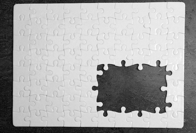 Photo puzzle blanc avec pièces manquantes sur fond gris