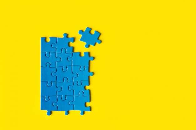 Puzzle bleu sur fond jaune, connexion commerciale, succès et concept de stratégie, travail d'équipe