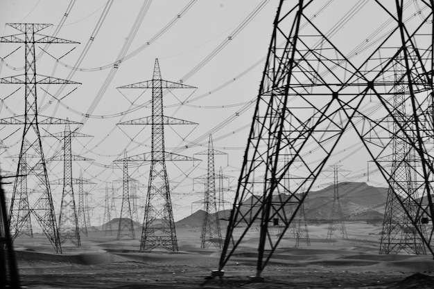 Pylône électrique par montagne contre le ciel