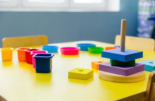 Pyramide de jouets éducatifs sur une table jaune