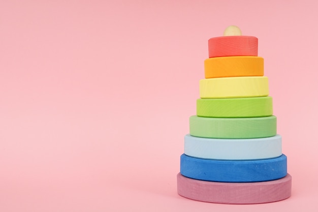 Photo pyramide multicolore en bois pour enfants sur fond rose avec fond