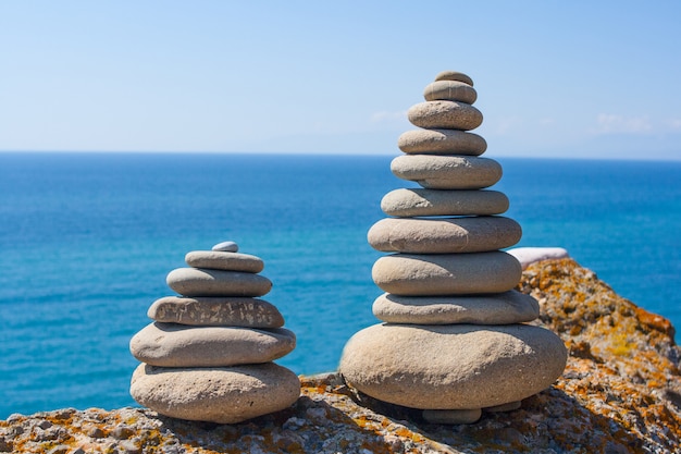 une pyramide de pierres et une vue sur la mer