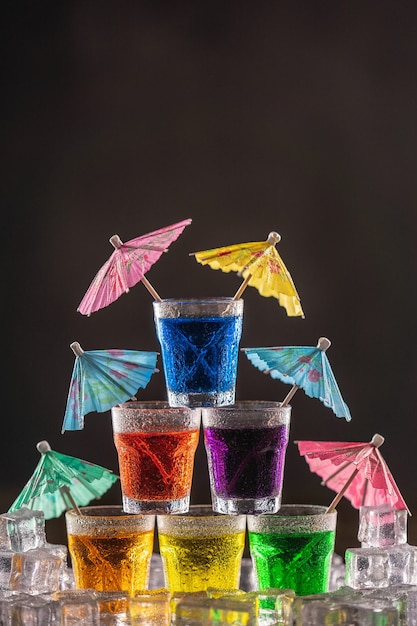 Pyramide de plans avec de l'alcool coloré, décorée de parapluies pour cocktails