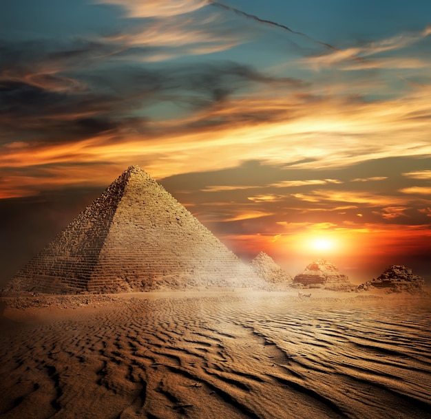 Pyramides égyptiennes dans le désert au coucher du soleil