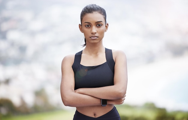 Qu'allez-vous sortir et réaliser aujourd'hui. Portrait d'une jeune femme sportive debout avec les bras croisés tout en faisant de l'exercice à l'extérieur.