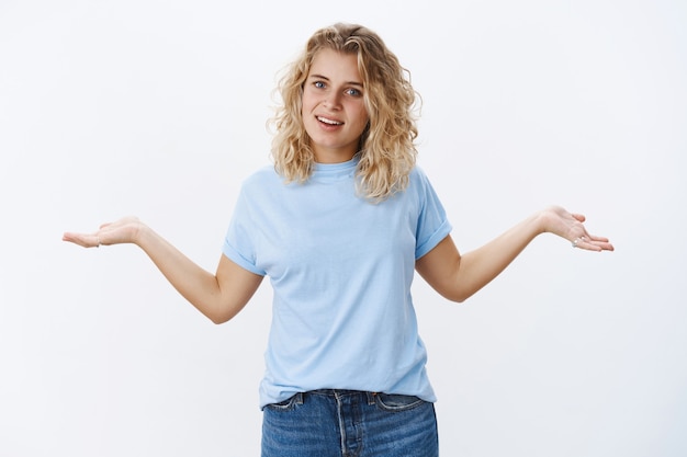 Qu'est-ce Que Tu Vas Faire. Petite Amie En Colère énervée Aux Cheveux Blonds Se Disputant, Debout, Irritée, Haussant Les épaules, Les Mains écartées Sur Le Côté Dans Une Pose Difficile, Interrogée Et Confuse