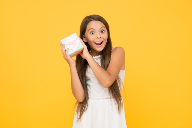 Qu'y a-t-il à l'intérieur de la beauté féminine aller faire du shopping petit accro du shopping avec achat temps de vacances petite fille tenir une boîte cadeau mode et beauté bonheur de l'enfance cadeau de fête des enfants heureux