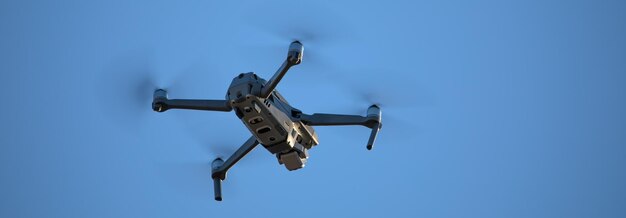 Quadcopter avec caméra photo et vidéo suspendu dans le ciel.