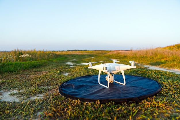 Photo quadcopter drone survolant le champ vert en été. l'innovation technologique dans l'industrie agricole