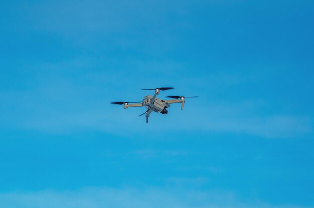 Quadricoptère de drone contre un ciel bleu Reconnaissance aérienne de tir aérien