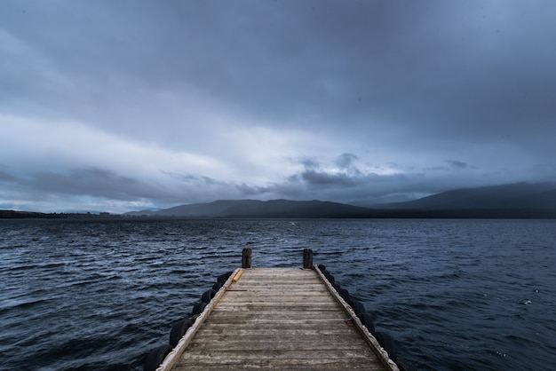 Quai en bois dans le lac avec la pluie en montagne