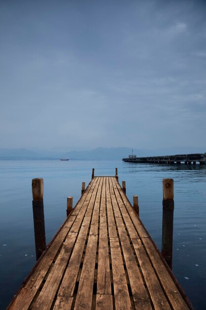 Un quai en bois avec un lac bleu en arrière-plan