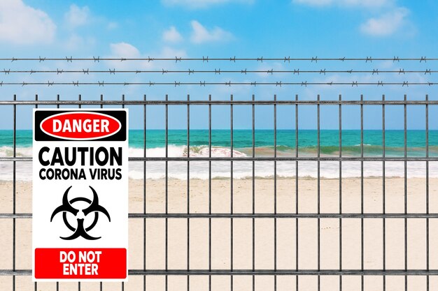 Quarantaine en raison du nouveau concept n-CoV 2019 du coronavirus COVID-19. Clôture métallique avec fil de fer barbelé et signe de danger de coronavirus devant le gros plan extrême de Sand Ocean Beach. Rendu 3D