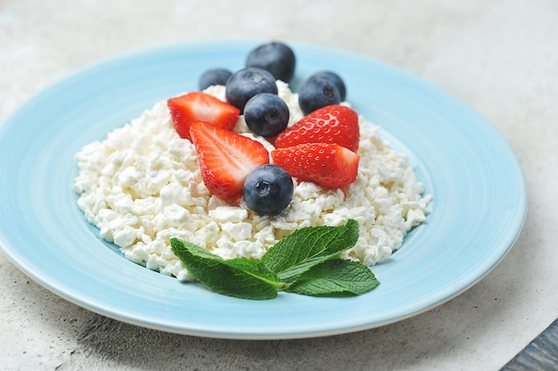 Photo quark et baies - bleuets, fraises et menthe avec du fromage cottage