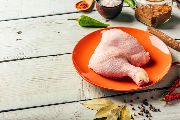 Quart de cuisse de poulet sur assiette avec différentes épices