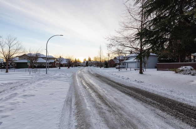 Quartier résidentiel en banlieue avec route couverte de neige blanche