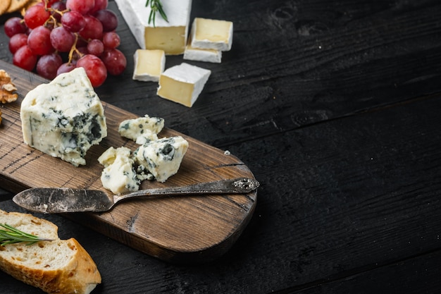 Quartiers de fromages bleus à pâte molle, sur table en bois noir