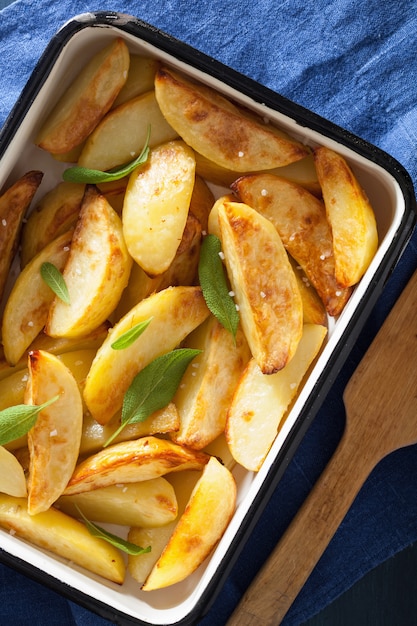 Photo quartiers de pommes de terre au four dans un plat de cuisson en émail