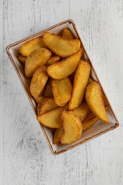 Quartiers de pommes de terre au four avec du fromage sur une vue de dessus de fond clair