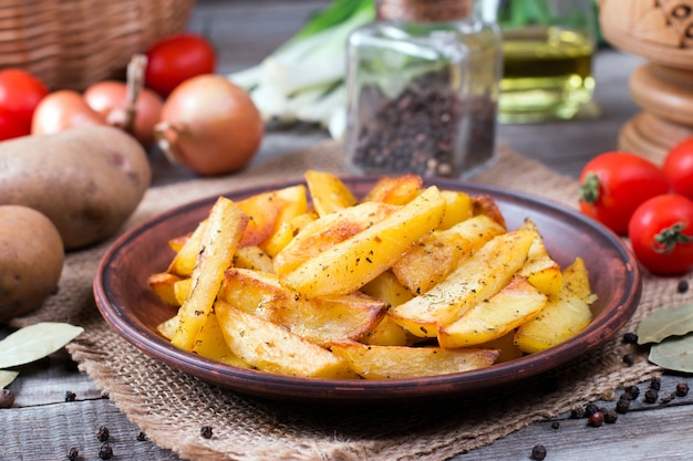 Quartiers de pommes de terre rôties aux herbes sur une assiette dans un style rustique