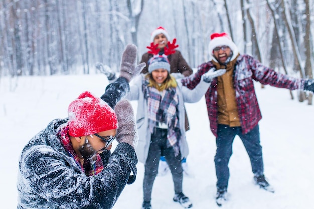 Quatre amis heureux s'amusent et jettent de la neige