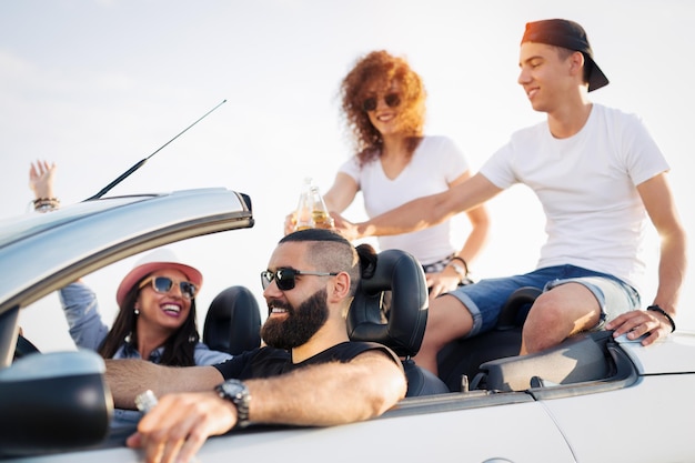 Quatre amis ont loué un cabriolet pour leurs vacances.