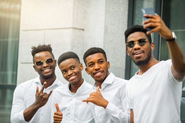 Quatre beaux jeunes hommes africains en chemises blanches