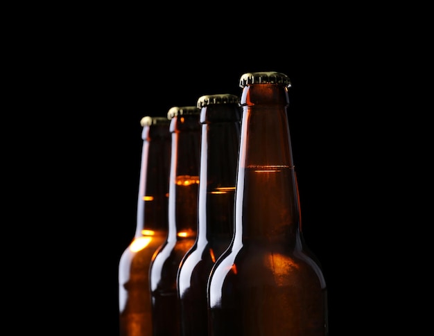 Quatre bouteilles de bière sur fond noir