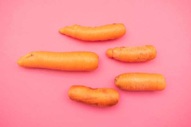 quatre carottes sont sur une surface rose avec le mot " quot " dessus