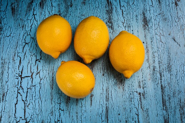 Quatre citrons sur table bleue