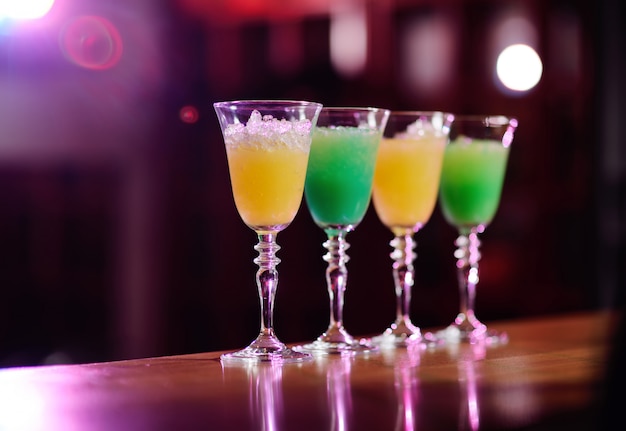 Quatre cocktails de fleurs jaunes et vertes sur le bar se bouchent