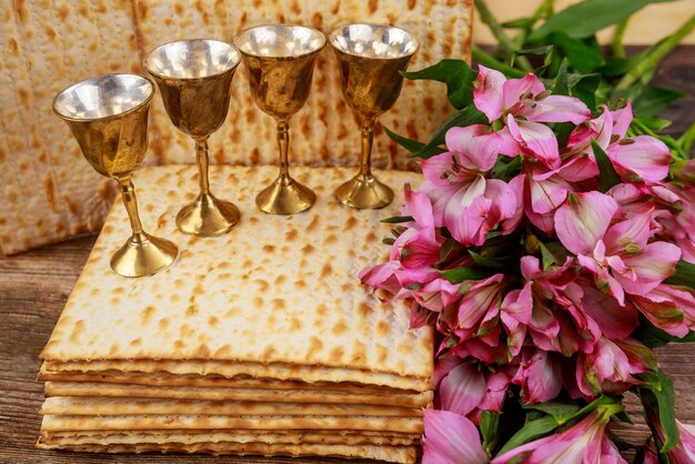 Photo quatre coupes pleines de vin avec matzah fêtes juives pâques