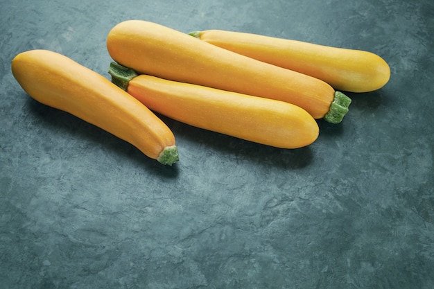 Quatre courgettes jaunes sur la table de la cuisine