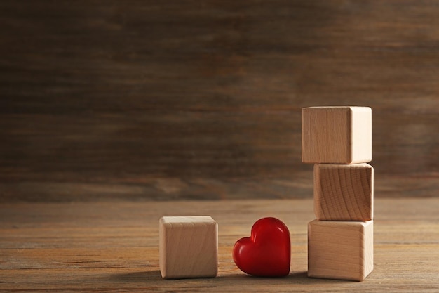 Quatre cubes en bois avec coeur rouge sur fond de bois je t'aime inscription